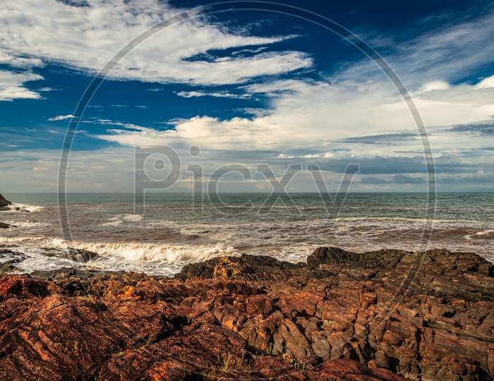 Rocky Sea Beach With Crashing Waves And Amazing Sky At Morning From Flat Angle