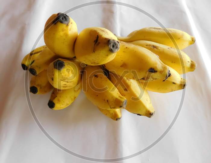 A Bunch Of Bananas Is Placed On A White Surface
