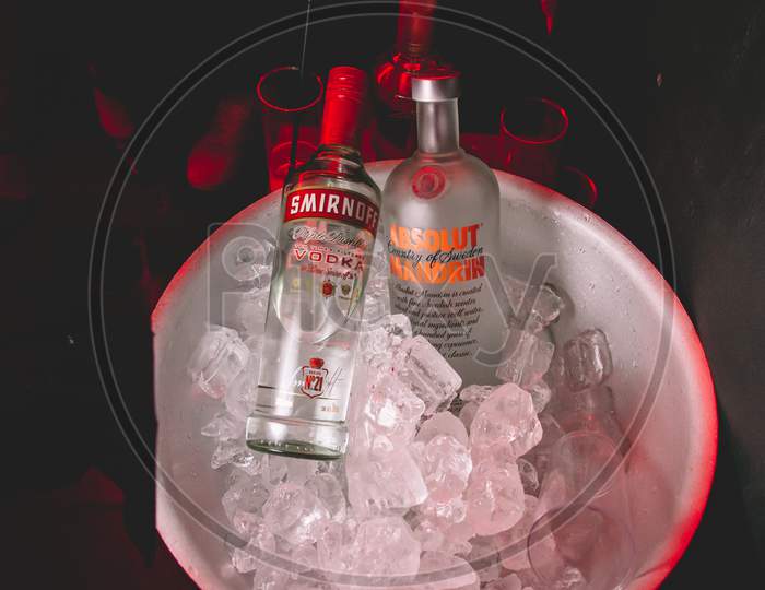 Two Bottles Of Smirnoff And Absolut Vodka In A Bowl With Ice