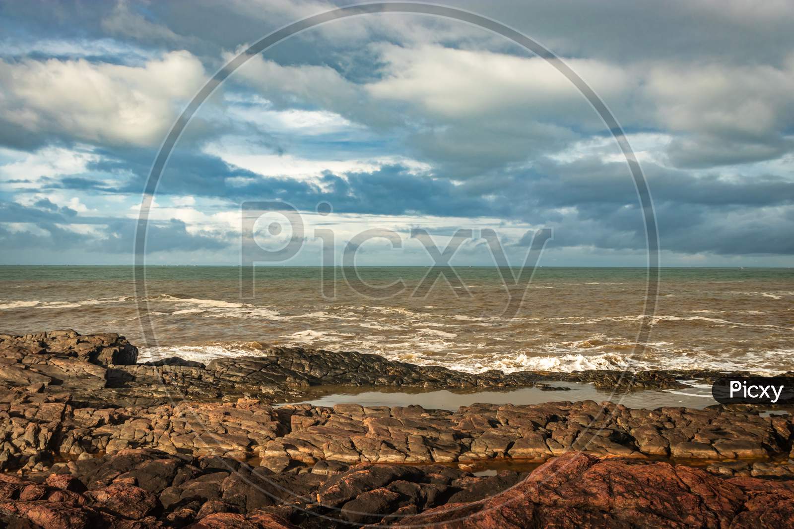 Rocky Sea Beach With Crashing Waves At Morning From Flat Angle
