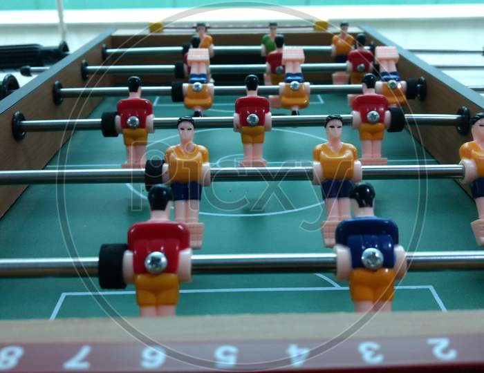 Foosball Table Football Game With Red And Yellow Players