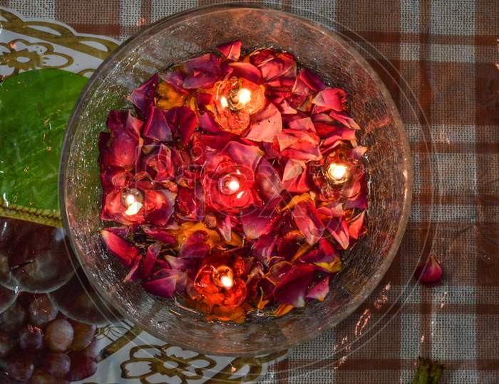 A Jar Is Which Is Loaded With Rose And Candle On Indian Festival Diwali Deepawali With Fire Isolated On Table