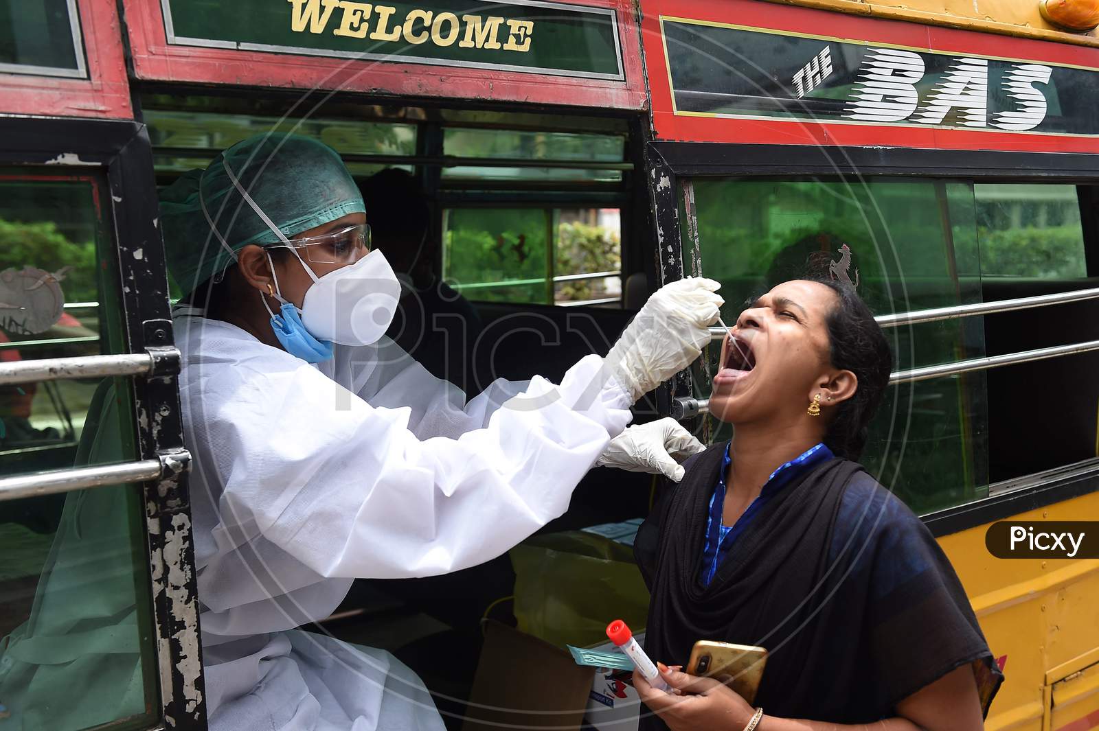 A Health Worker Wearing Personal Protective Equipments (Ppe) Suit, Sits In A Share Auto-Rickshaw As She Collects A Swab Sample From A Women To Test For The Covid-19 Coronavirus, Outside A Commercial Centre In Chennai On September 15, 2020.