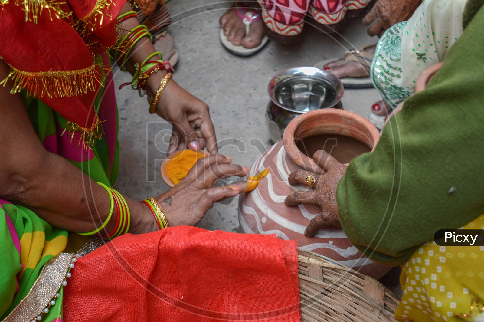 Lady Putting Turmeric On Clay Pot In Indian Weddings.