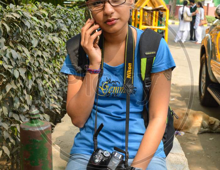 A Portrait Of Student Of Photography Who Is Talking From Mobile At Lodhi Garden Park With Nikon Camera.
