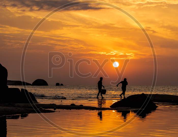 Sunset at a rocky beach with beautiful reflection in the water