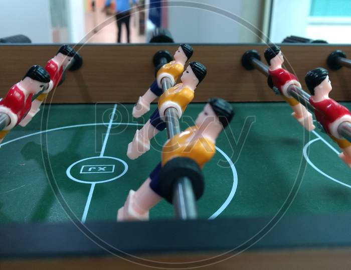 Foosball Table Football Game With Red And Yellow Players