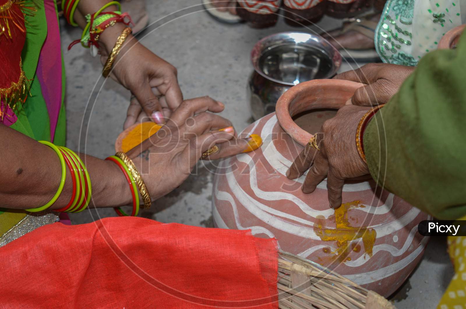 Lady Putting Turmeric On Clay Pot In Indian Weddings.