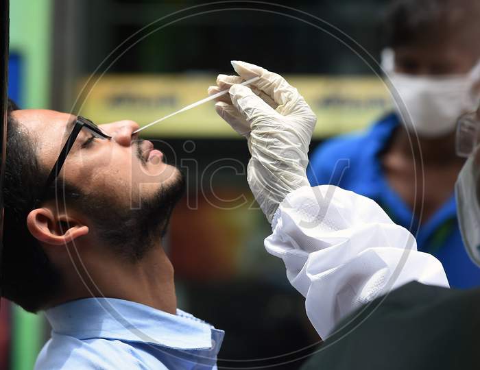 A Health Worker Wearing Personal Protective Equipments (Ppe) Suit, Sits In A Share Auto-Rickshaw As She Collects A Swab Sample From A Man To Test For The Covid-19 Coronavirus, Outside A Commercial Centre In Chennai On September .15.2020