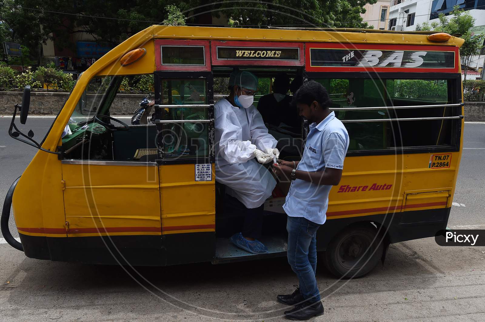 A Health Worker Wearing Personal Protective Equipments (Ppe) Suit, Sits In A Share Auto-Rickshaw As She Collects A Swab Sample From A Man To Test For The Covid-19 Coronavirus, Outside A Commercial Centre In Chennai On September .15.2020