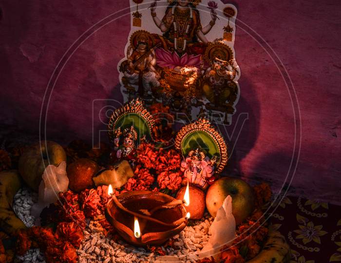 Indian God Statue With Rose And Candle On Indian Festival Diwali Deepawali With Fire Isolated On Table
