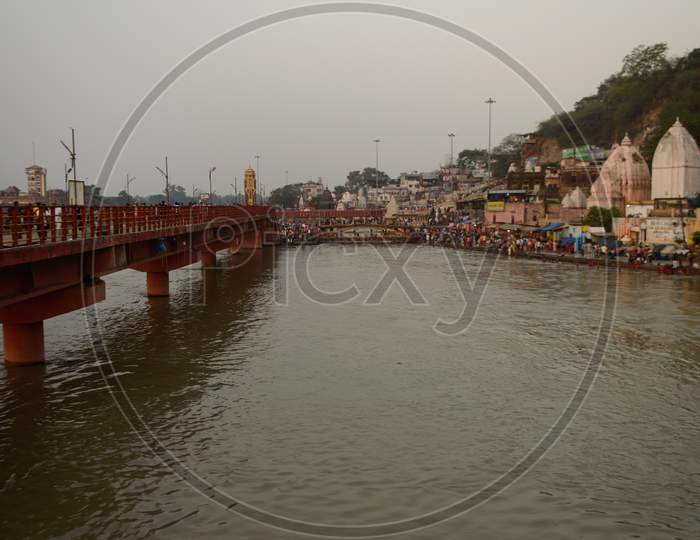 A Landscape View Of Bridge At Ganga River In Haridwar Public Going To Take Bath In Ganga River Temple Sky.