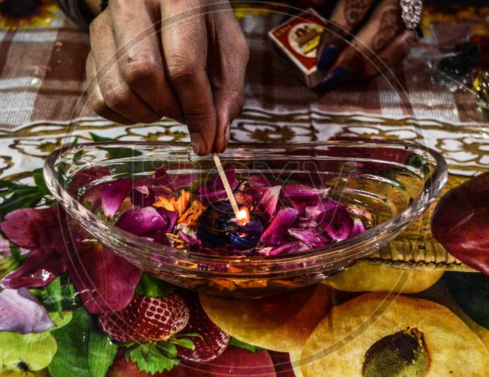 A Indian Lady Lit Up A Jar Is Which Is Loaded With Rose And Candle On Indian Festival Diwali Deepawali With Fire Isolated On Table