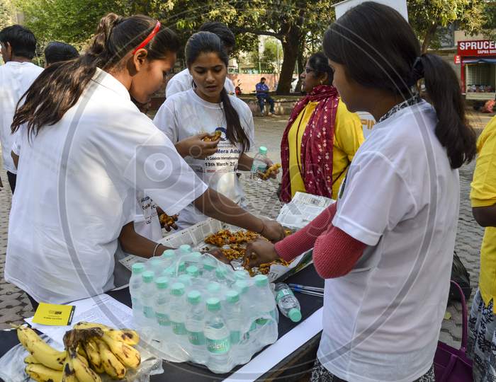 A Group Of Indian People Having The Food At Event For Support The Cycle Ride To Celebrate International Women'S Day.