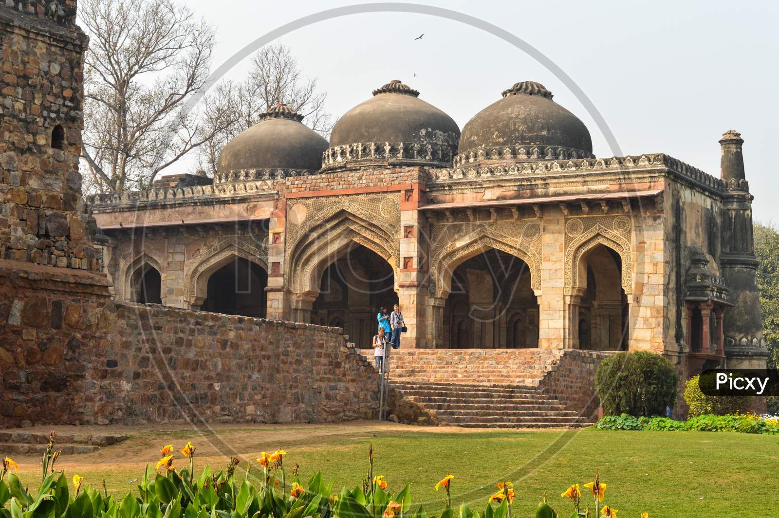 A Bada Gumbad Monument At Lodi Garden Or Lodhi Gardens In A City Park From The Side Of The Lawn At Winter Foggy Morning.