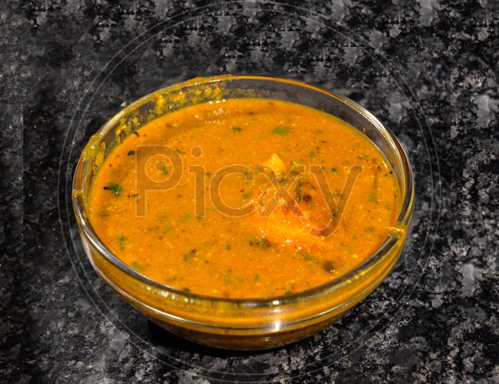 Egg Curry In Bowl Isolated On Black Marble With Chilli.