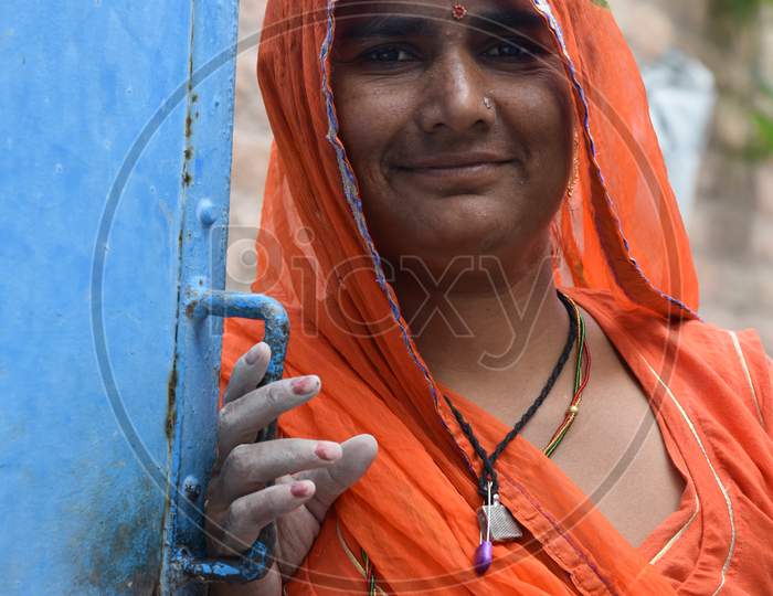 Bikaner, Rajasthan / India, October,19,2019 : Closeup view a woman standing near the door in traditional jewelery and traditional Rajasthani dress in the house of Gangeshahar, Bikaner
