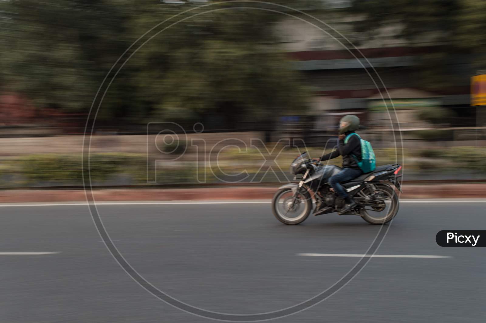 Panning Technique Of Biker Who Is Going For Some Work At Evening On The Road