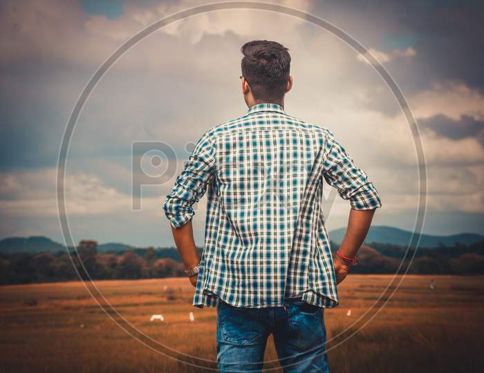 A man boy standing in open field and see the nature and inspired