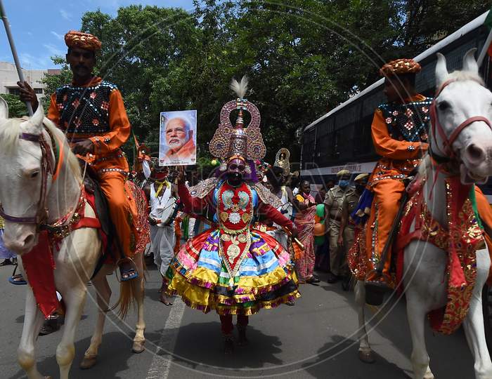 A 'Therukoothu' folk artist holds a placard with the image of Indian Prime Minister Narendra Modi during Bharatiya Janata Party (BJP) celebrations for Modi's 70th birthday, in Chennai on September 17, 2020.