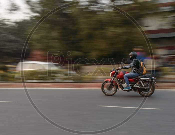 Panning Technique Of Red And Black Bike Going Somewhere At Evening On The Road