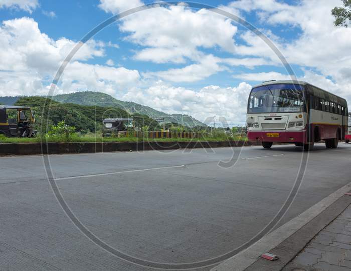 A Beautiful view of Mysuru Cityscape with the City Bus and the Chamundi Hills in the Background against the rich blue sky and the Clouds in Karnataka state of India.