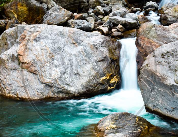 Amaizing view of a waterfall with blue water and big rock  in sikkim Gangtok