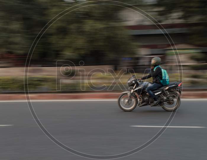 Panning Technique Of Biker Who Is Going For Some Work At Evening On The Road