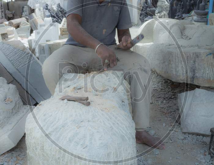 A Stone Sculpture artist is seen Chiseling away the rough pieces to create a Beautiful Statue out of it in Mysuru city of Karnataka state in India.