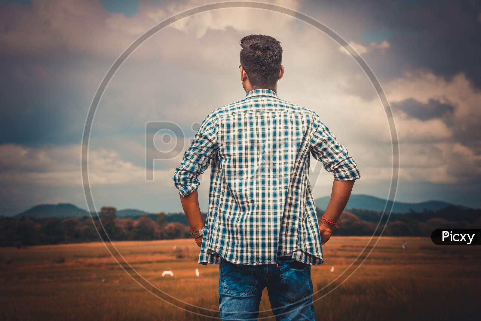 A man boy standing in open field and see the nature and inspired