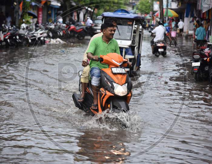 Commuters travel through a flooded street after heavy rains  in Nagaon district, in the northeastern state of Assam on sep 17,2020.