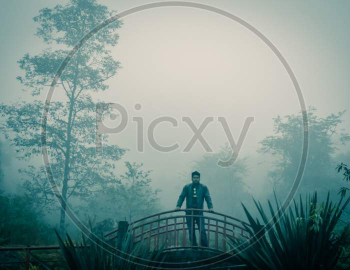 A Boy Man standing in bridge in foggy misty day morning gangtok sikkim