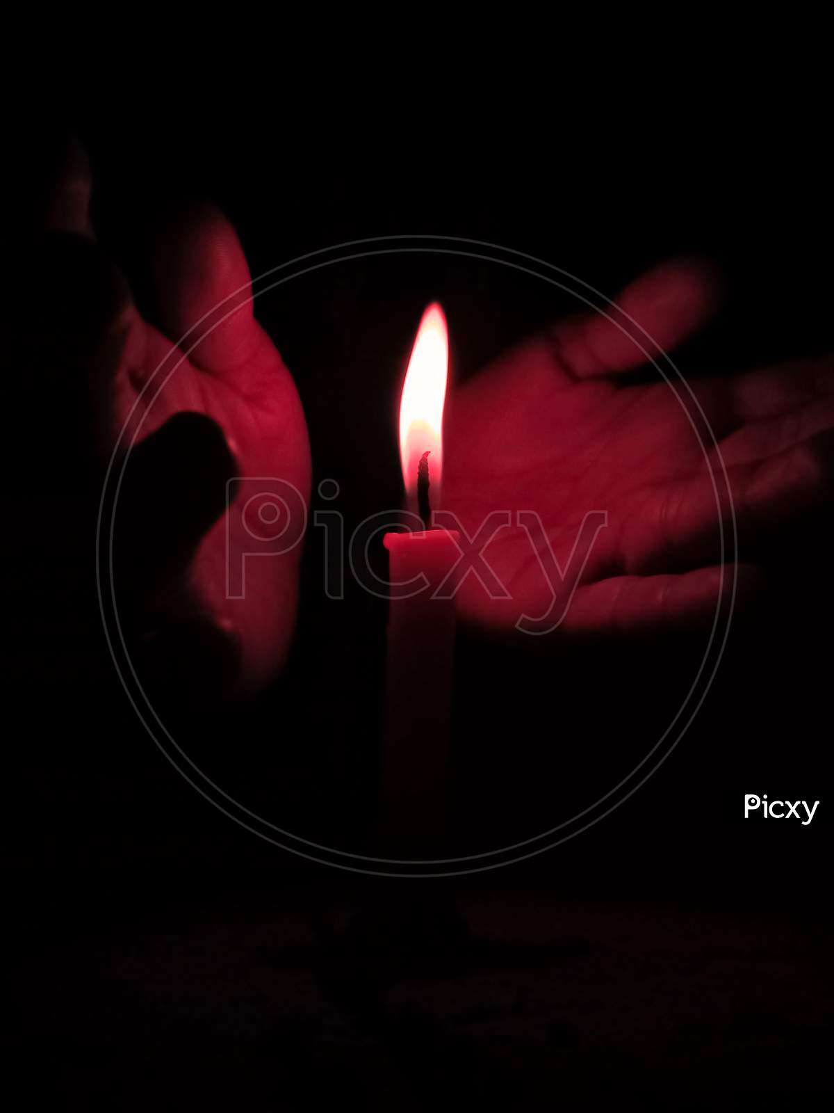 Small Hands Protecting Flames Of Candle From Air