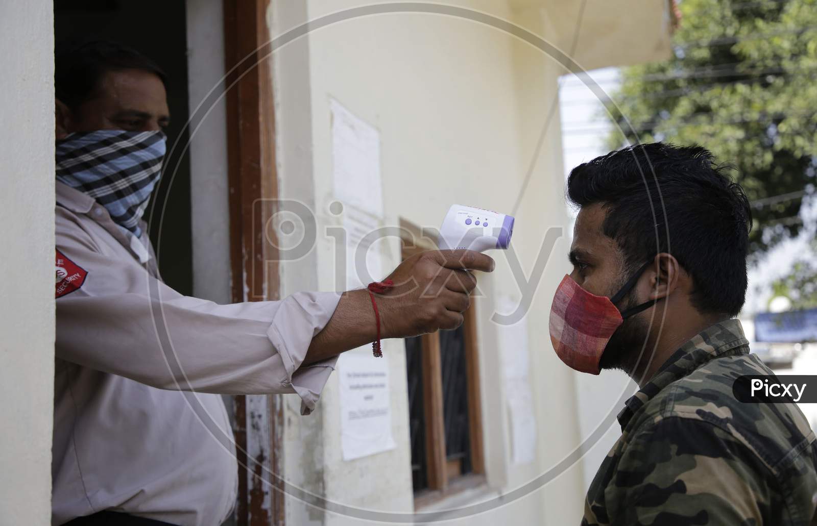 School staff being checked for body temperature before allowing  with circles to ensure social distancing  among students as preparations are underway to open the educational institutions in Jammu for select classes after nearly six months closure due to the outbreak of Coronavirus pandemic on Septe