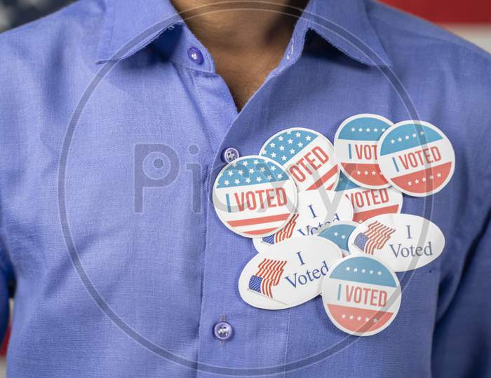 Close Up Of Multiple I Voted Stickers On Blue Shirt - Concept Of Us Election Voter Fraud By Placing Multiple Voting Stickers