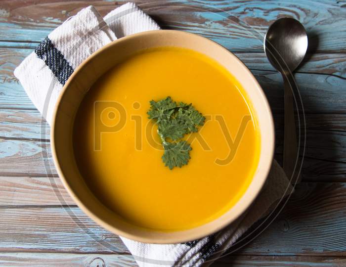 Fresh pumpkin soup and parsley in a bowl