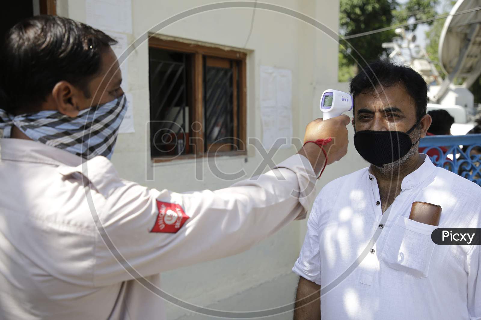 School staff being checked for body temperature before allowing  with circles to ensure social distancing  among students as preparations are underway to open the educational institutions in Jammu for select classes after nearly six months closure due to the outbreak of Coronavirus pandemic on Septe