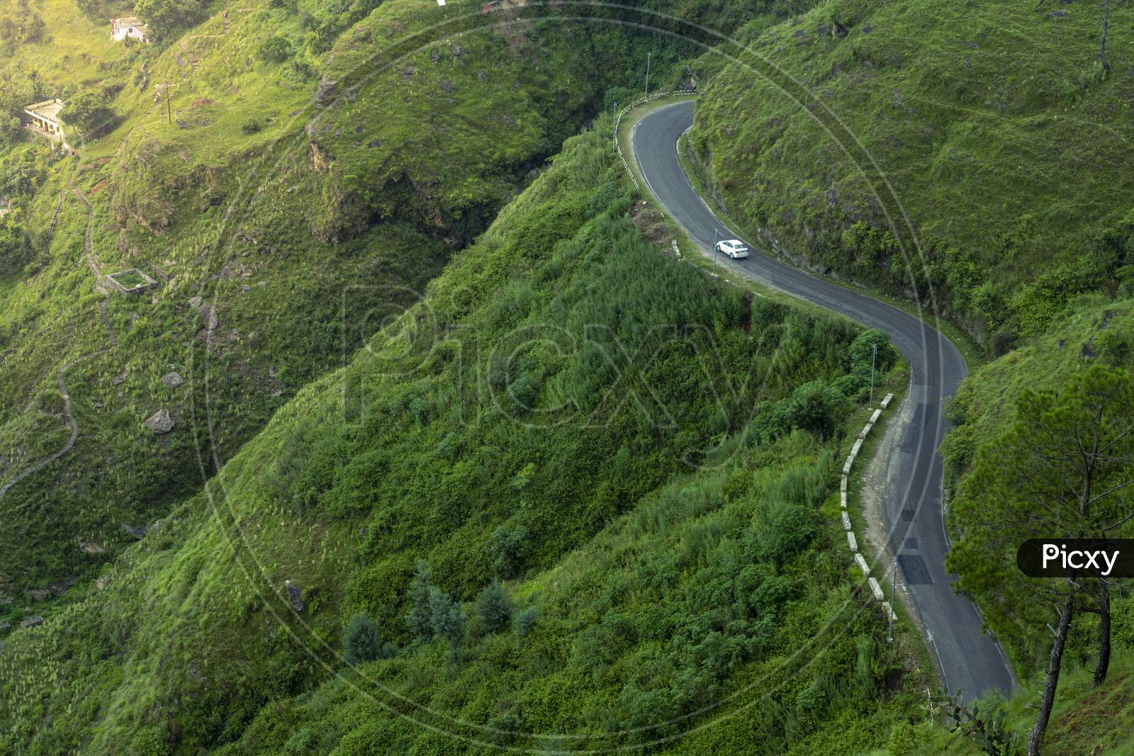 A Road In The Green Mountains With A Car.