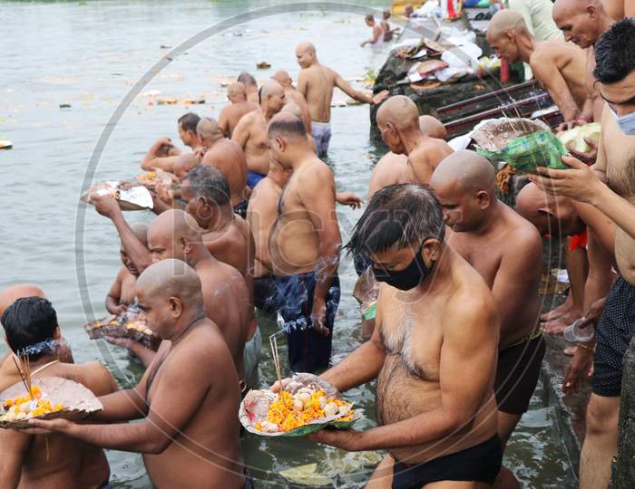 People pray as they take a dip in a lake to honour the souls of their departed ancestors on the last day of Sarva pitru amavasya, amid the spread of the coronavirus disease (COVID-19) in Mumbai, India on September 17, 2020.