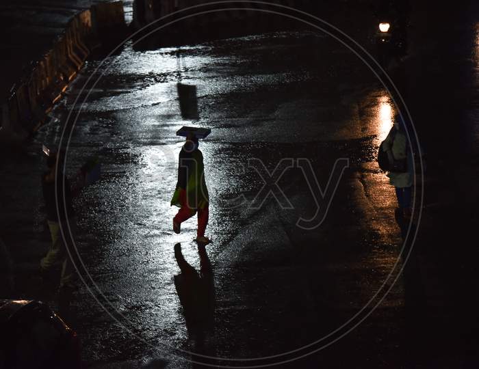 People walk on road as it rains heavily in Hyderabad, September, 16, 2020.