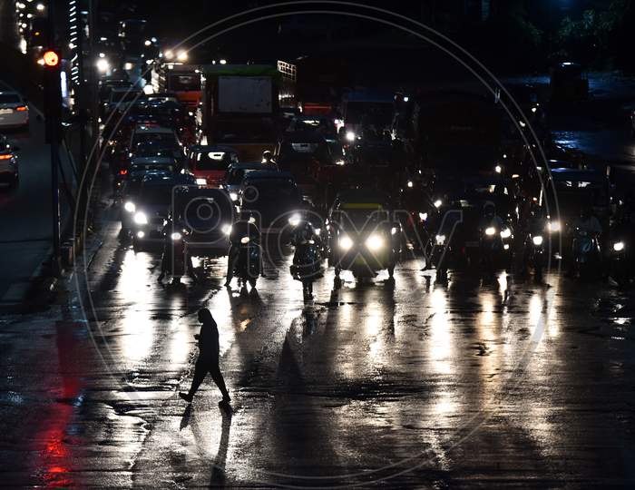 a man crosses road at a traffic signal as it rains heavily in Hyderabad, September 16,2020