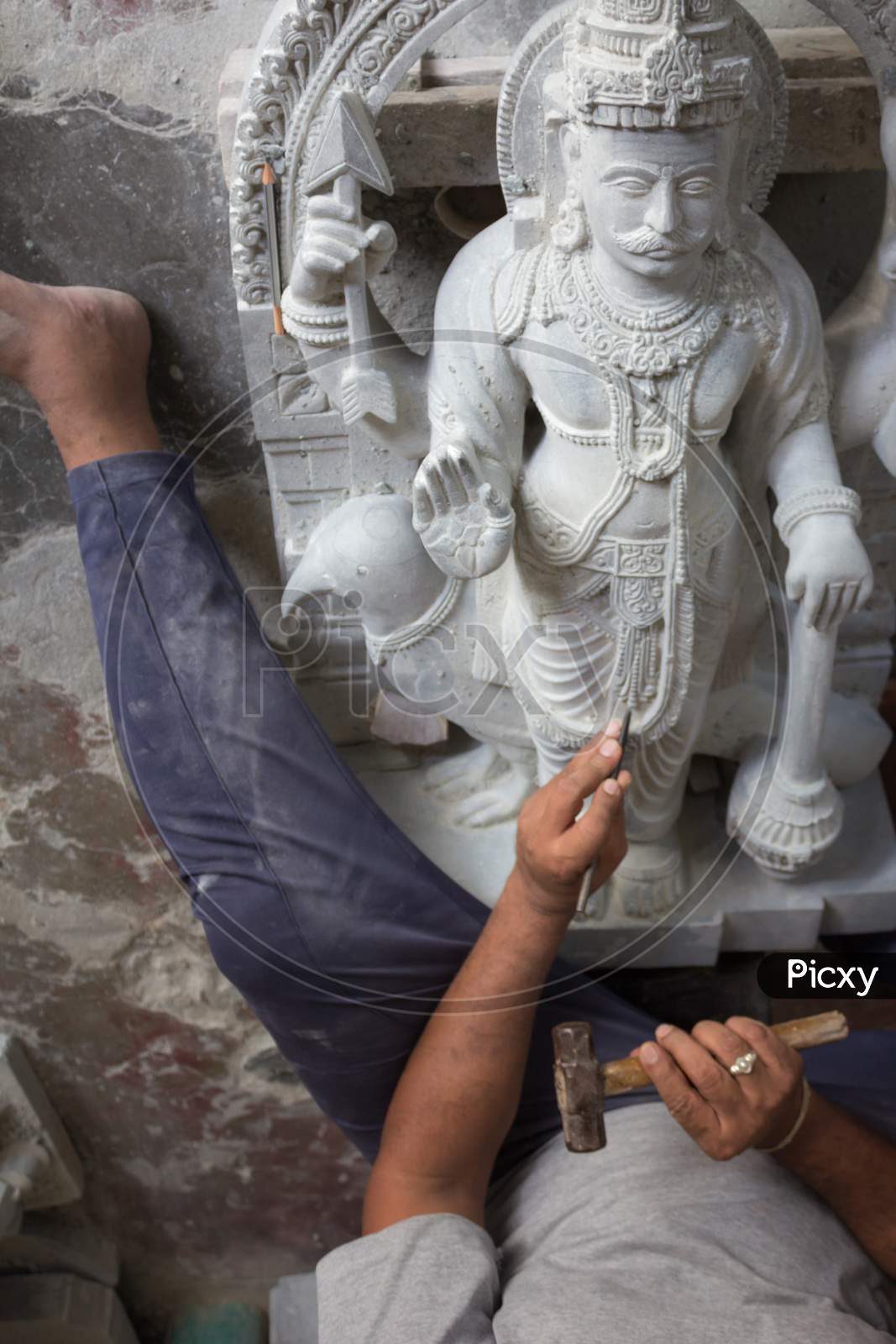 A Stone Sculpture Artist is seen giving Finishing touch to his creation of Statue of God which is then  placed in a Hindu temple at Mysuru in Karnataka state of India.
