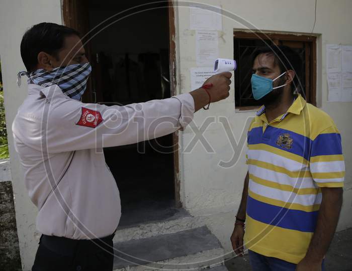 Parents being checked for body temperature before allowing  with circles to ensure social distancing  among students as preparations are underway to open the educational institutions in Jammu for select classes after nearly six months closure due to the outbreak of Coronavirus pandemic on September