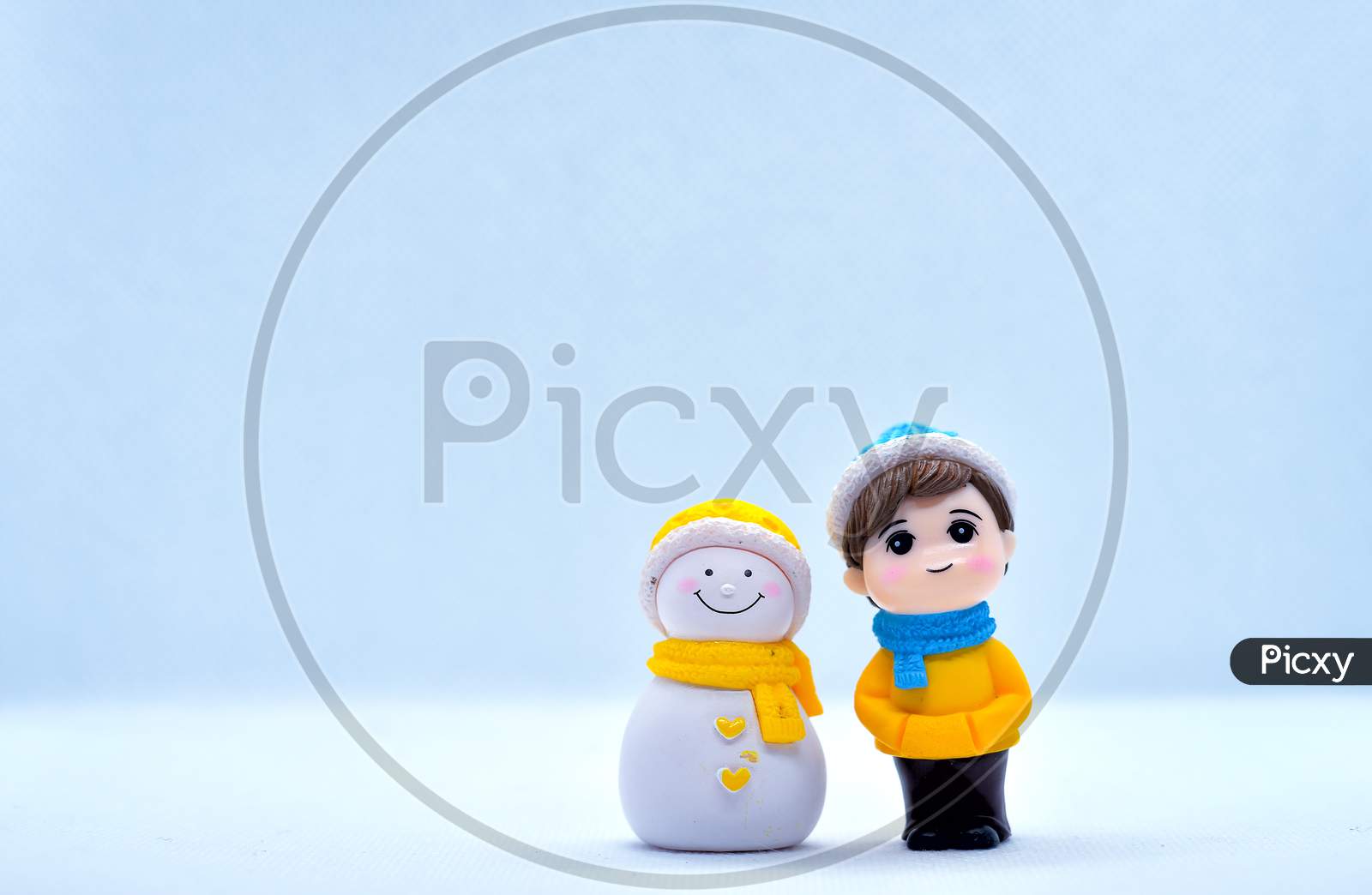 Tourism And Travel Concept: Miniature Little Boy And Snowman Standing In Isolated Background