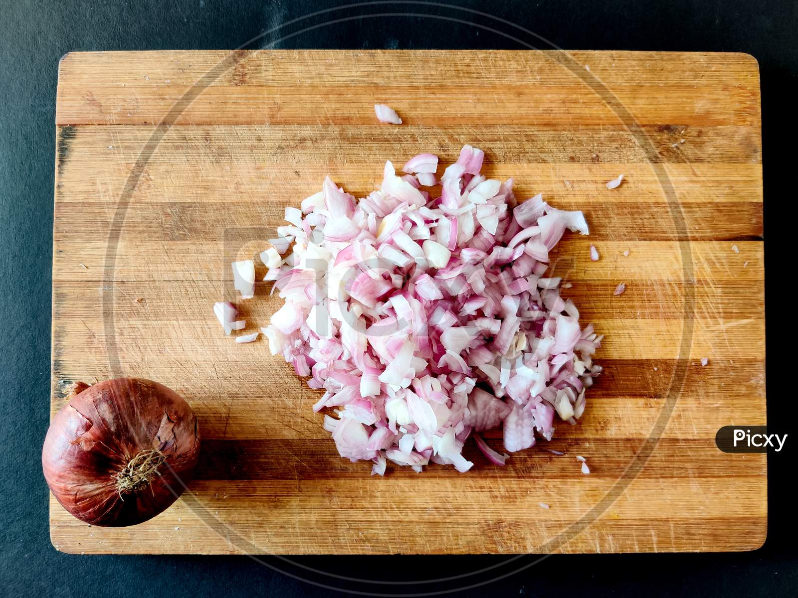 Raw Onion Chopped Into Small Cubes. Isolated On Wooden Board.