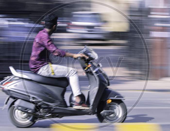 Scooter Rider in Motion Blur Photograph
