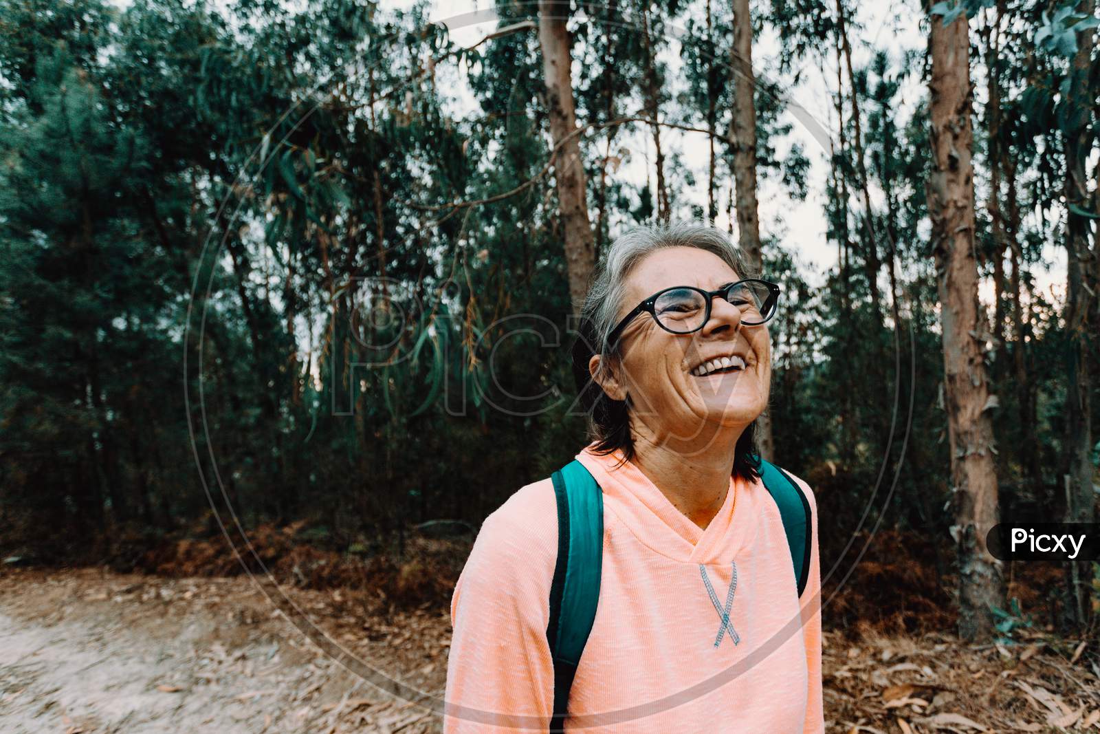 Old Woman Laughing In The Middle Of The Forest In Spain Wearing Sport Clothes With Copy Space