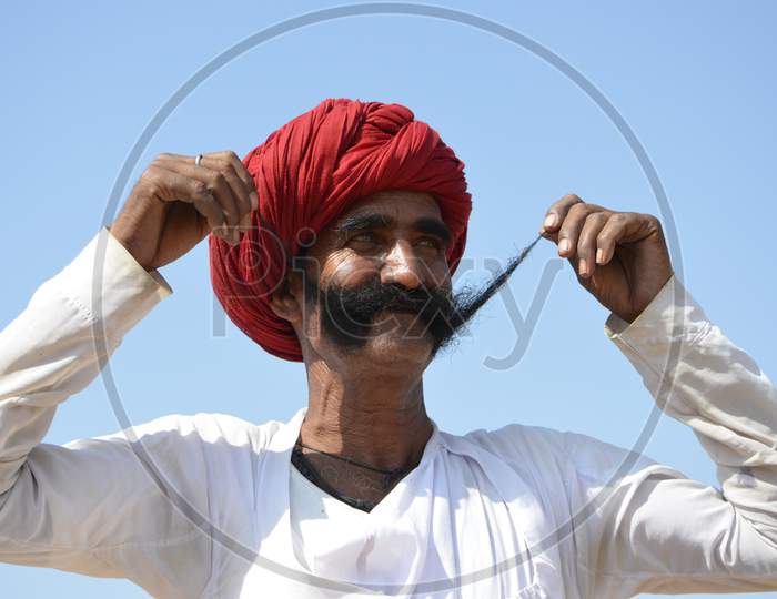 rural man wearing a Rajasthani turban while enjoying the Pushkar fair.