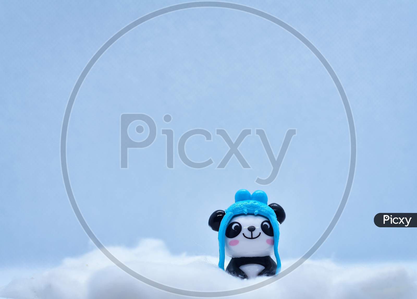 Little Panda Porcelain Figurine In Winter Snow Isolated On Black Background