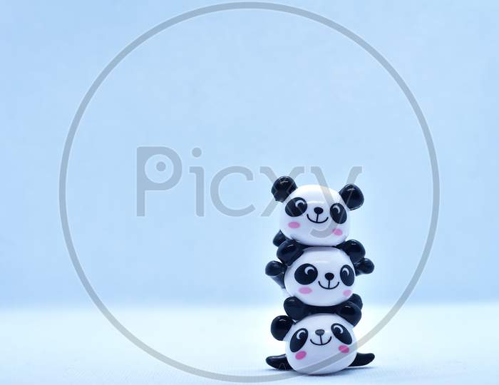 Little Panda Stacked Porcelain Figurines Isolated On Black Background